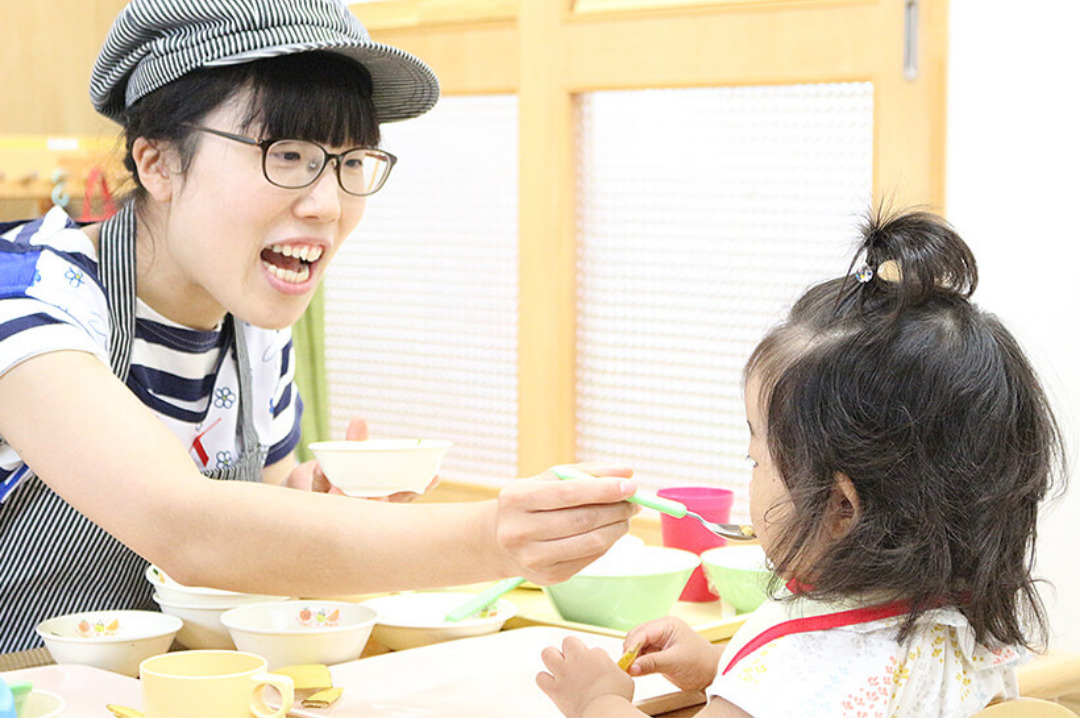子どもに食事を食べさせる様子
